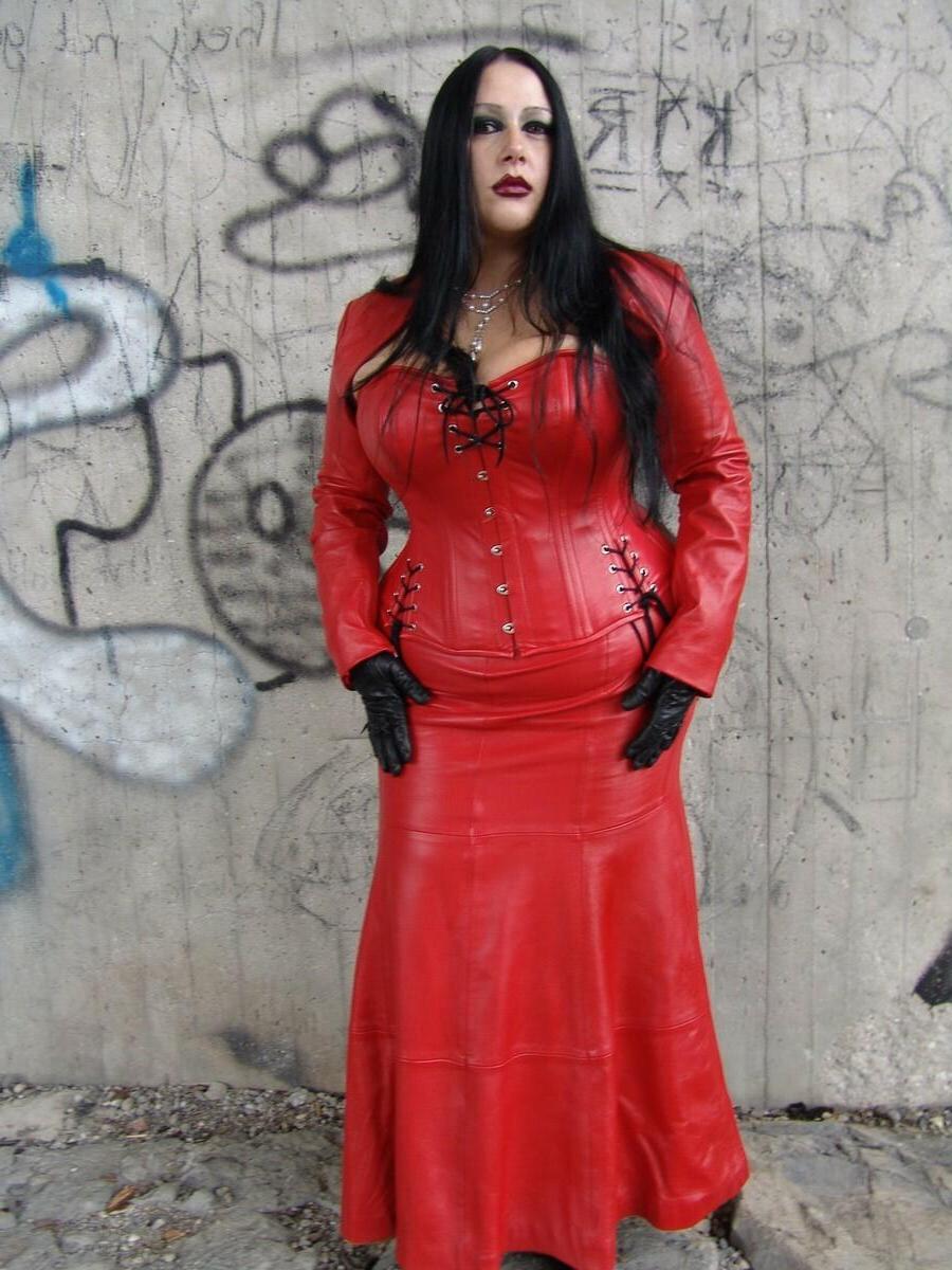 16P La mujer de cabello oscuro Lady Angelina libera sus grandes tetas de la ropa de látex roja