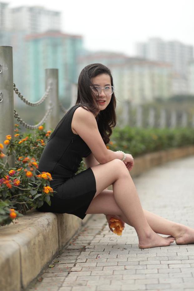 20P Nena asiática descalza hace una provocación caliente con un vestido negro sexy al aire libre