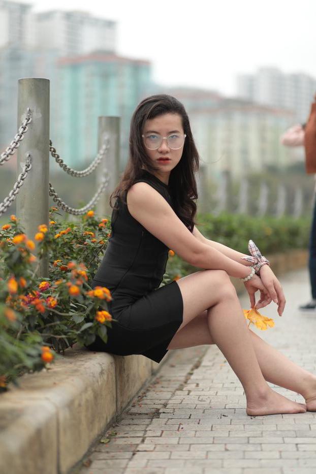 20P Nena asiática descalza hace una provocación caliente con un vestido negro sexy al aire libre