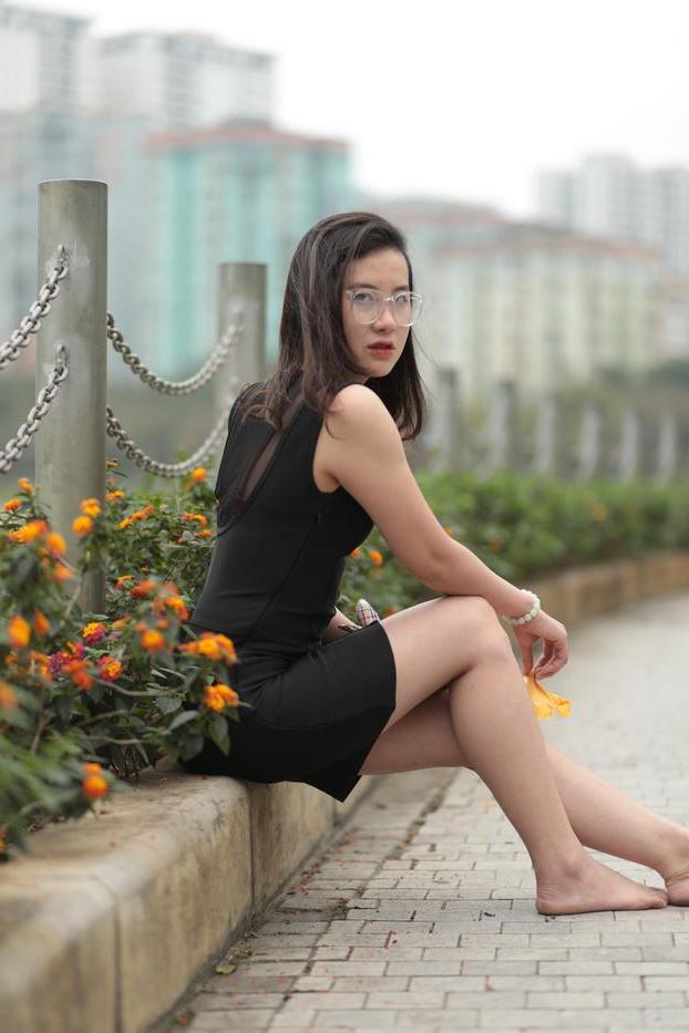 20P Nena asiática descalza hace una provocación caliente con un vestido negro sexy al aire libre