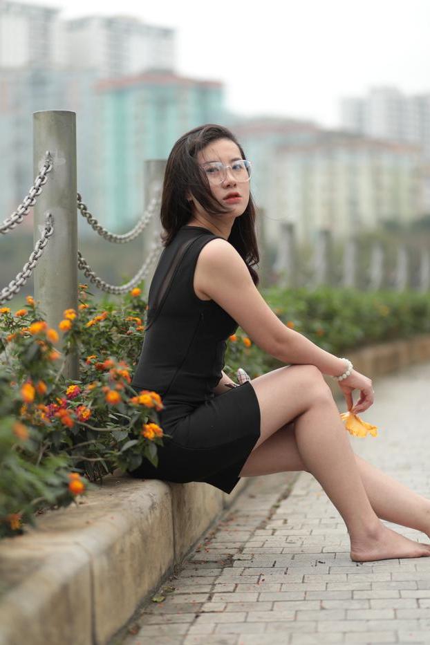 20P Nena asiática descalza hace una provocación caliente con un vestido negro sexy al aire libre