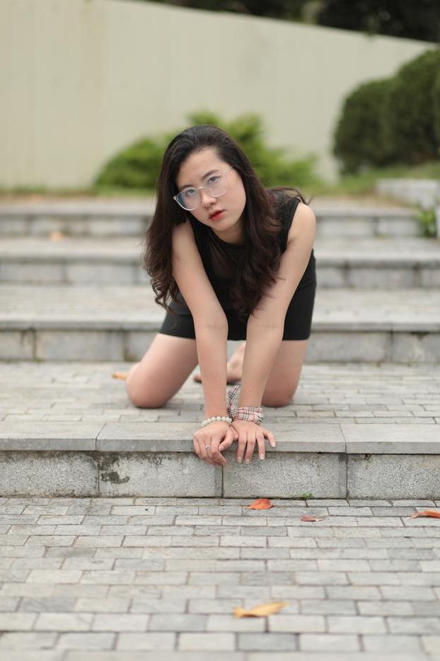 20P Nena asiática descalza hace una provocación caliente con un vestido negro sexy al aire libre