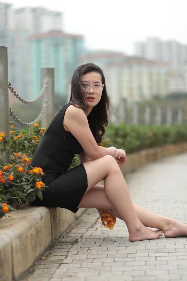 20P Nena asiática descalza hace una provocación caliente con un vestido negro sexy al aire libre