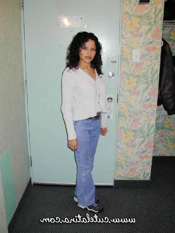 15P Une latina aux cheveux bouclés montre son cul nu sur un lit.