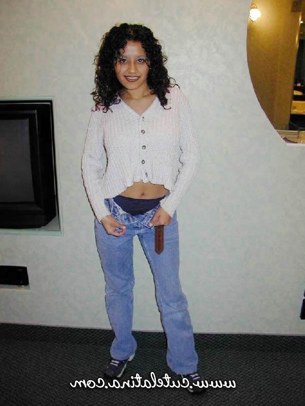 15P Une latina aux cheveux bouclés montre son cul nu sur un lit.