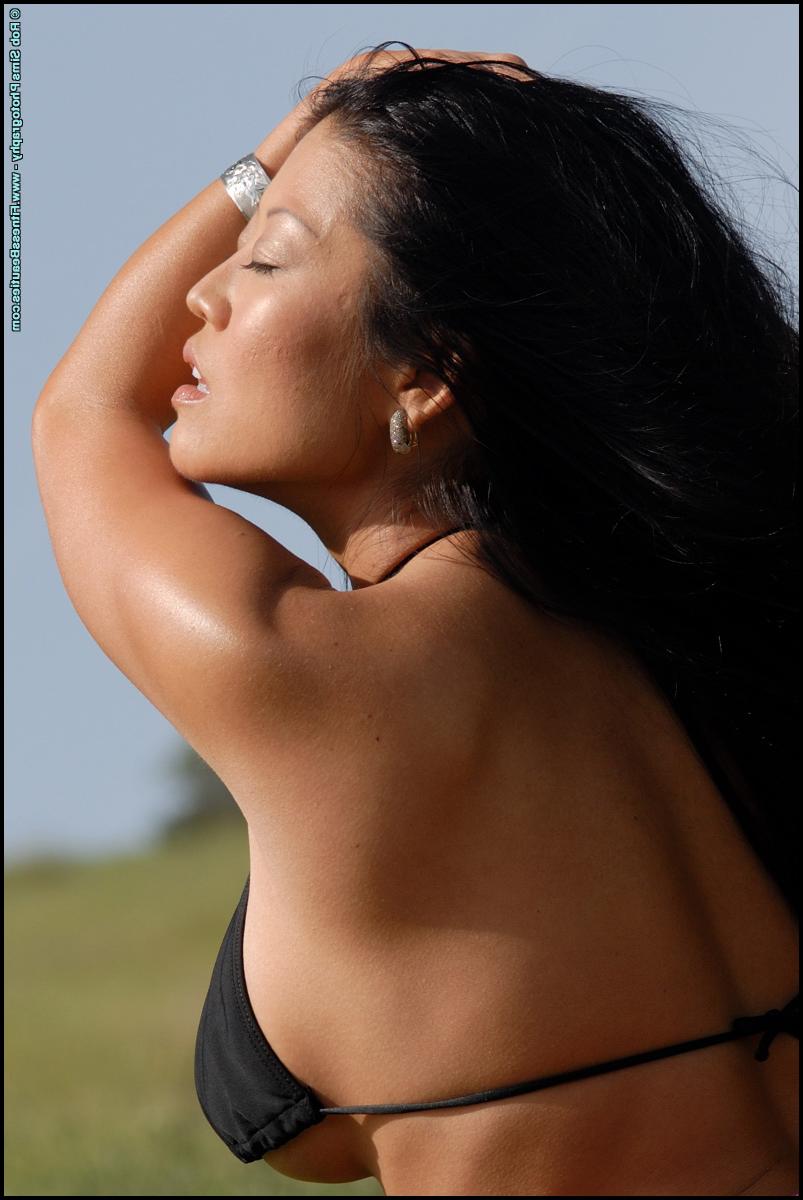 15P Asian fitness model Natile undoes the straps of her bikini top out in nature