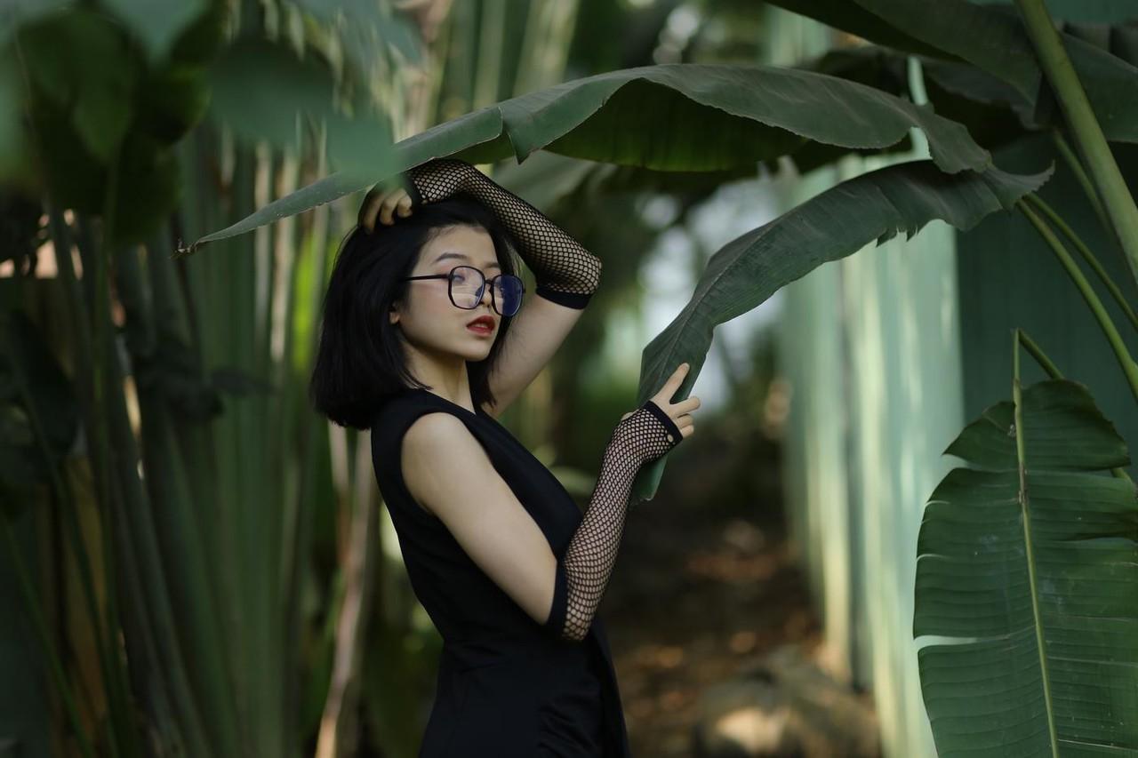 20P La pequeña asiática con gafas irena posando con su largo vestido negro al aire libre