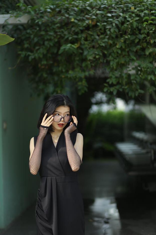 20P La pequeña asiática con gafas irena posando con su largo vestido negro al aire libre