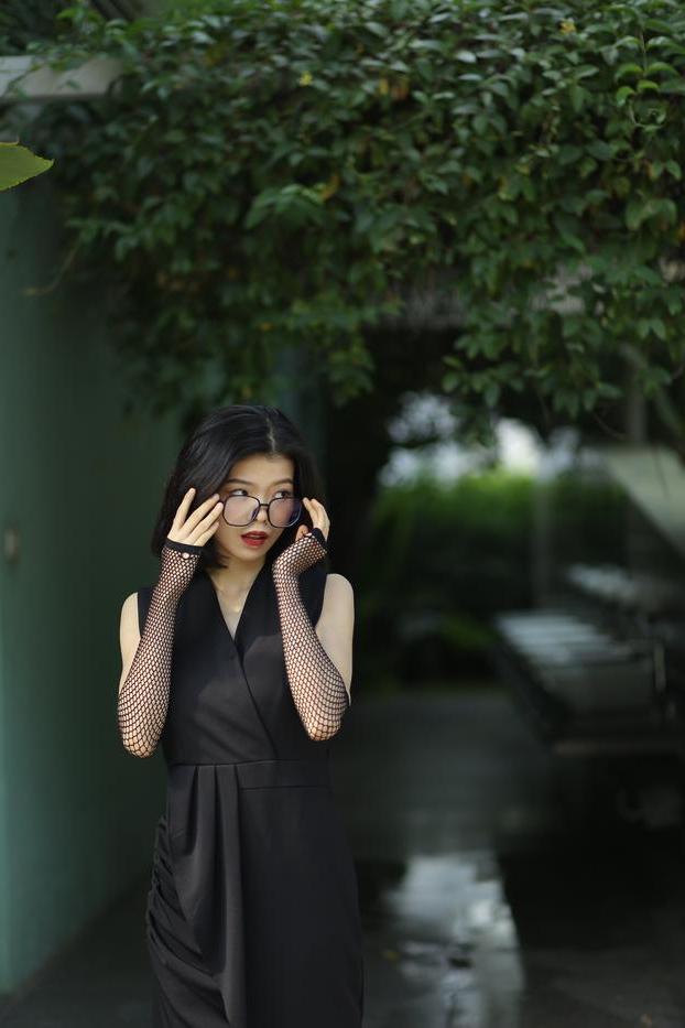 20P La pequeña asiática con gafas irena posando con su largo vestido negro al aire libre