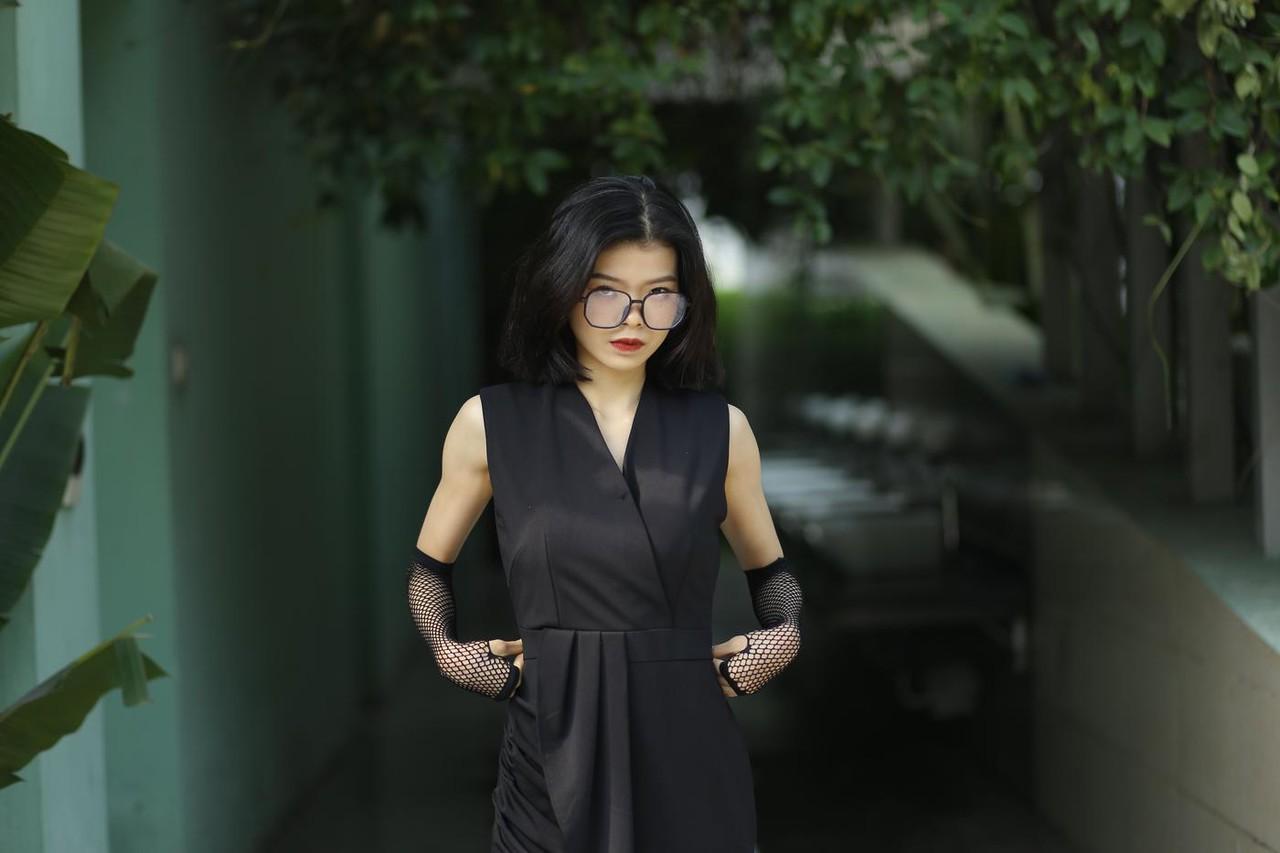 20P La pequeña asiática con gafas irena posando con su largo vestido negro al aire libre