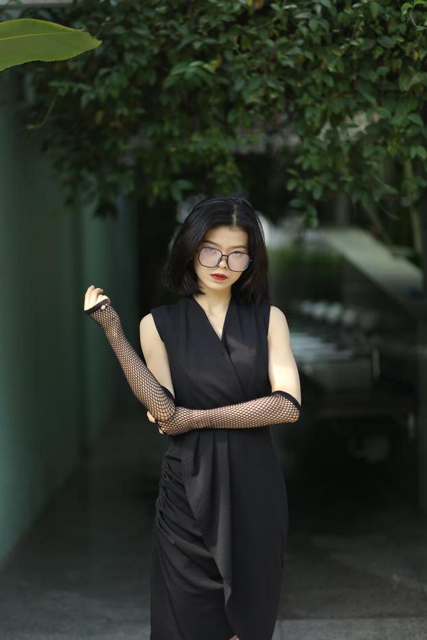20P La pequeña asiática con gafas irena posando con su largo vestido negro al aire libre