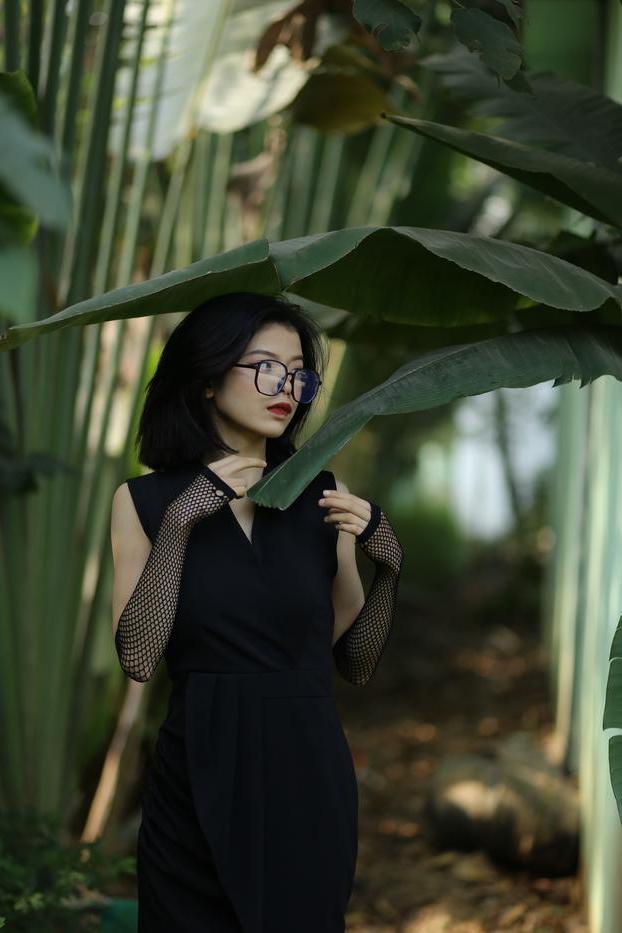 20P La pequeña asiática con gafas irena posando con su largo vestido negro al aire libre