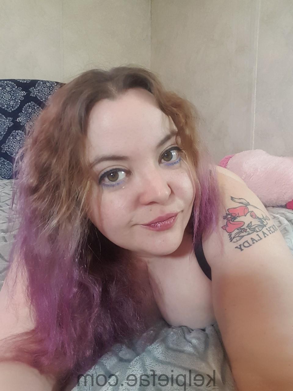 15P Inked chubby amateur Kelpie Fae poses in black underwear on her bed