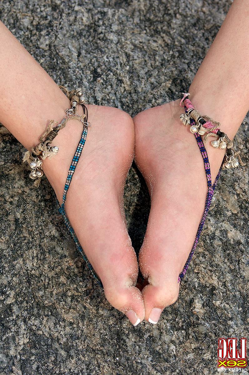 16P Amadora loira exibe os pés descalços na praia com pulseiras nos tornozelos e dedos dos pés