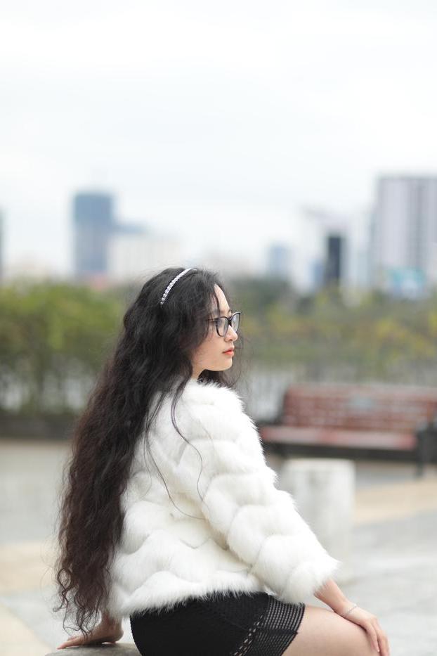 20P Jolie asiatique avec des lunettes posant dans son manteau de fourrure et sa robe en plein air