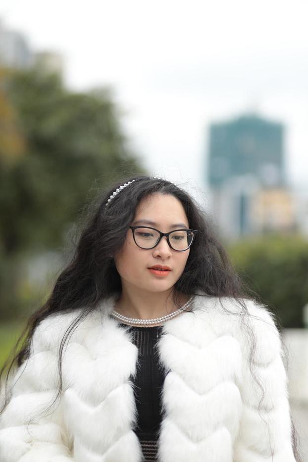 20P Jolie asiatique avec des lunettes posant dans son manteau de fourrure et sa robe en plein air