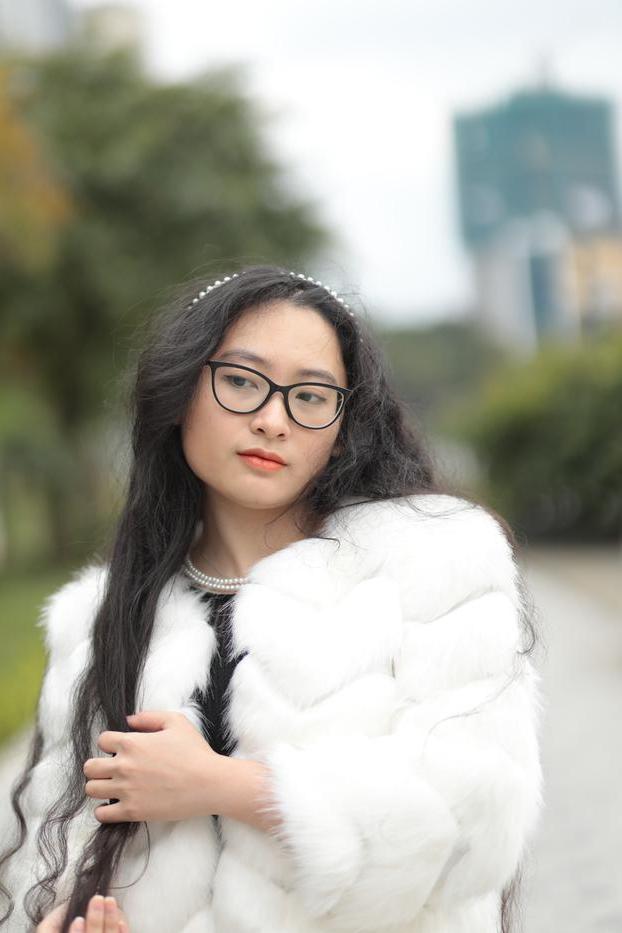 20P Jolie asiatique avec des lunettes posant dans son manteau de fourrure et sa robe en plein air