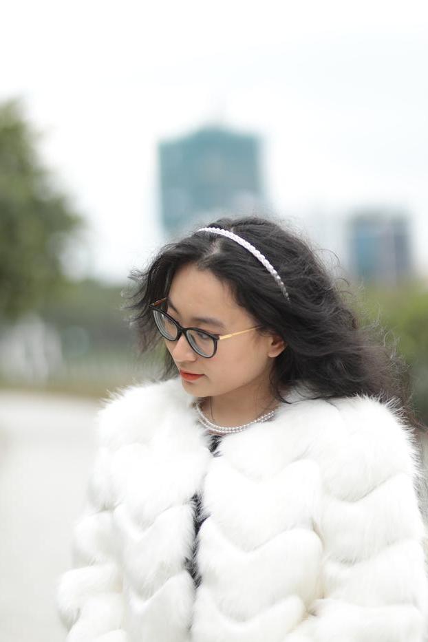 20P Jolie asiatique avec des lunettes posant dans son manteau de fourrure et sa robe en plein air