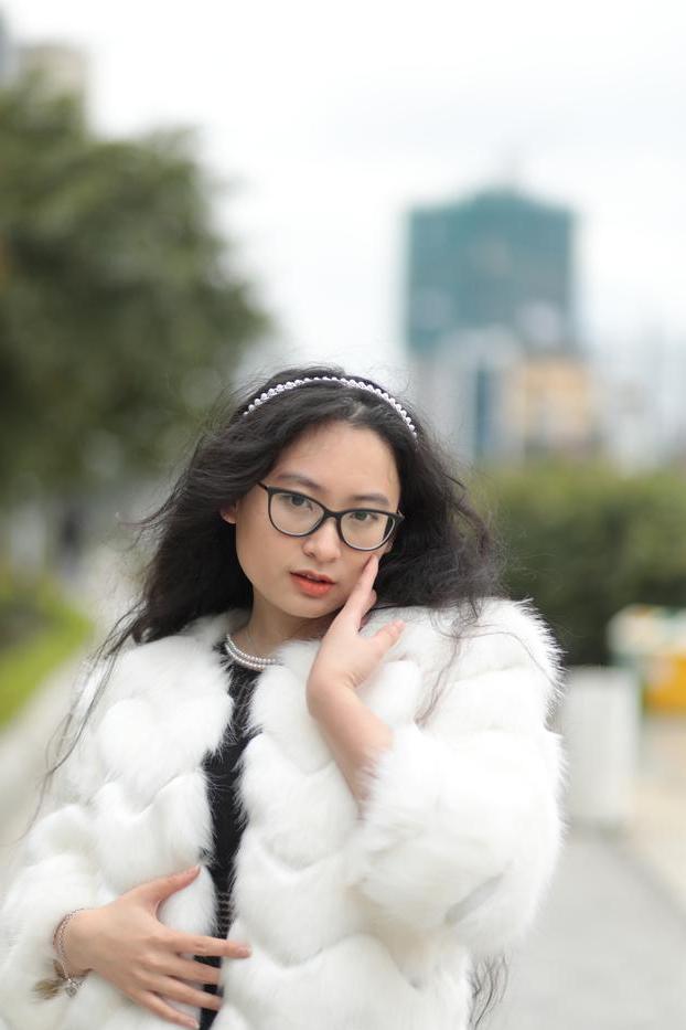 20P Jolie asiatique avec des lunettes posant dans son manteau de fourrure et sa robe en plein air