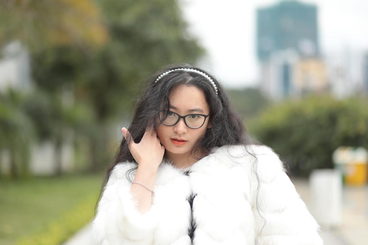 20P Jolie asiatique avec des lunettes posant dans son manteau de fourrure et sa robe en plein air