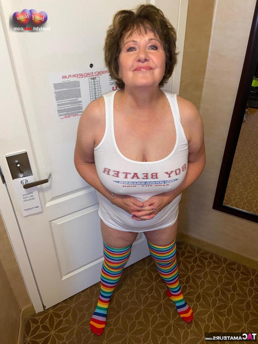 16P A senhora madura Busty Bliss fica nua enquanto usa meias arco-íris na altura da coxa