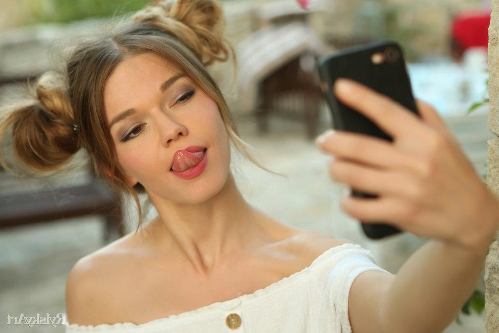 16P A linda adolescente Nedda lambe os lábios enquanto tira uma selfie em puffballs
