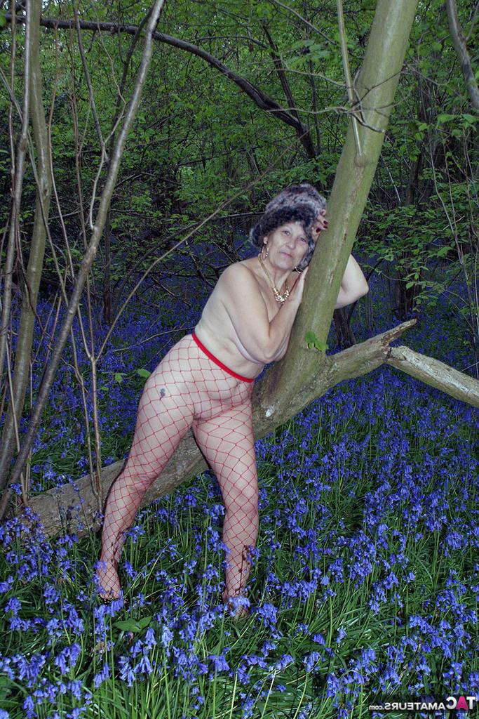 20P Senhora madura tira o casaco de inverno para mostrar seus grandes traços naturais em meia-calça de malha