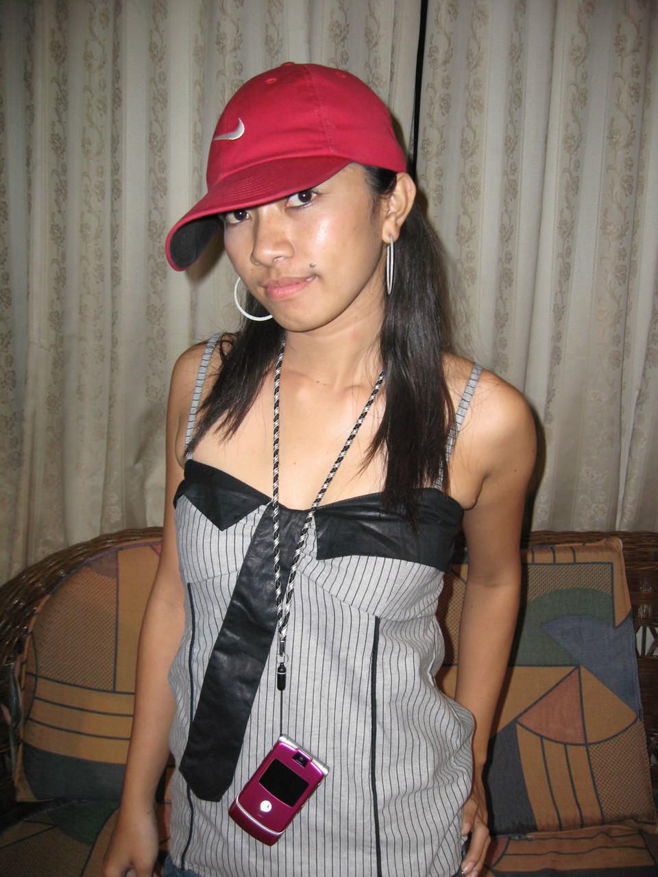 14P Junges Pinay-Mädchen mit Nike-Baseballkappe zieht sich auf einem Zweiersofa aus