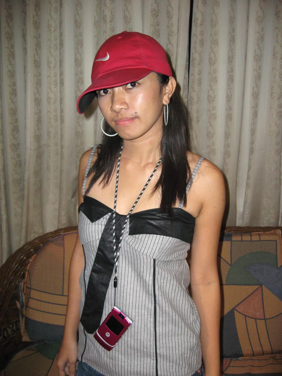 14P Junges Pinay-Mädchen mit Nike-Baseballkappe zieht sich auf einem Zweiersofa aus