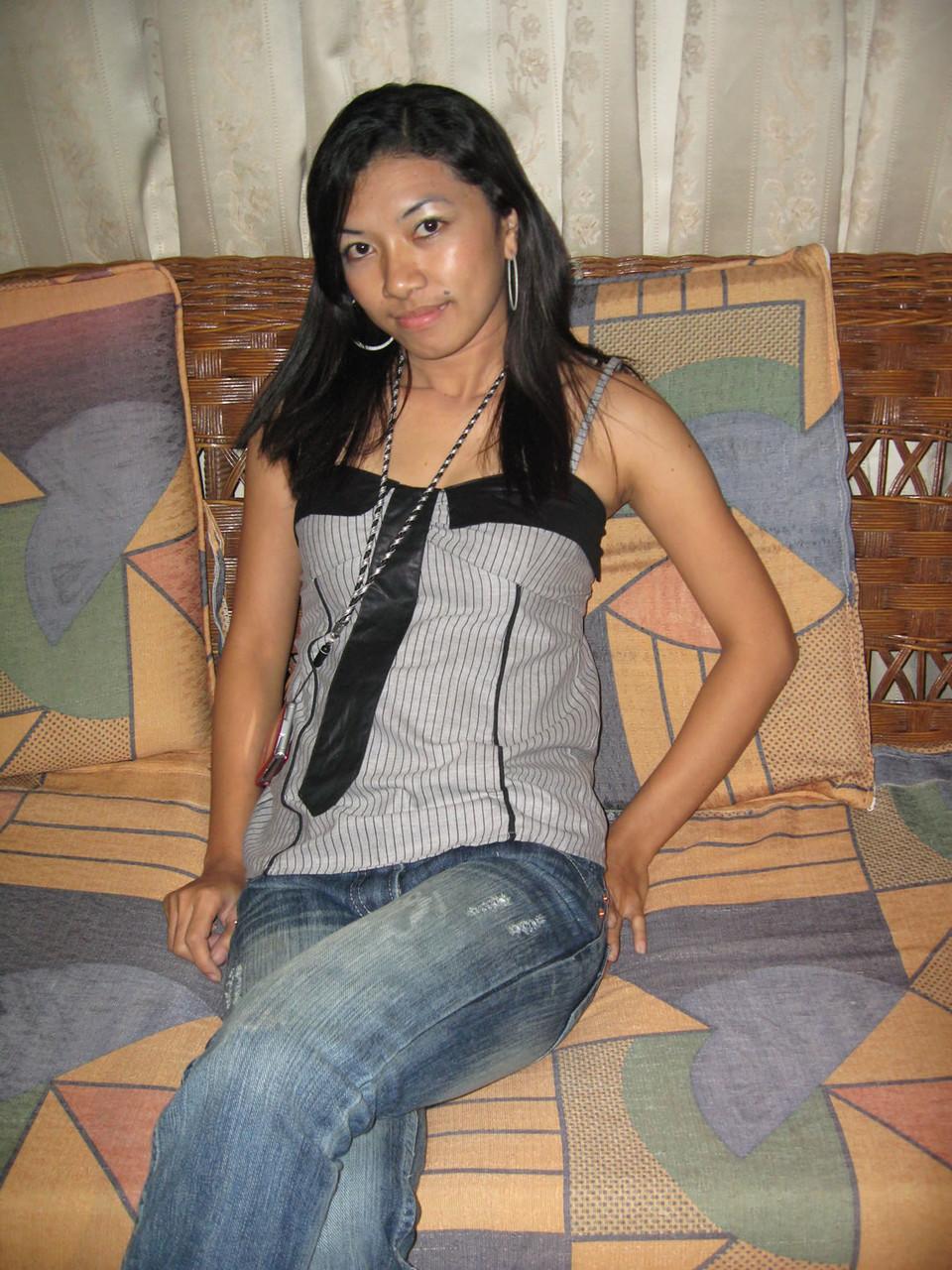 14P Junges Pinay-Mädchen mit Nike-Baseballkappe zieht sich auf einem Zweiersofa aus