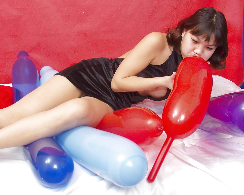 16P Garota tailandesa safada em vestido sexy brincando com um grande balão vermelho