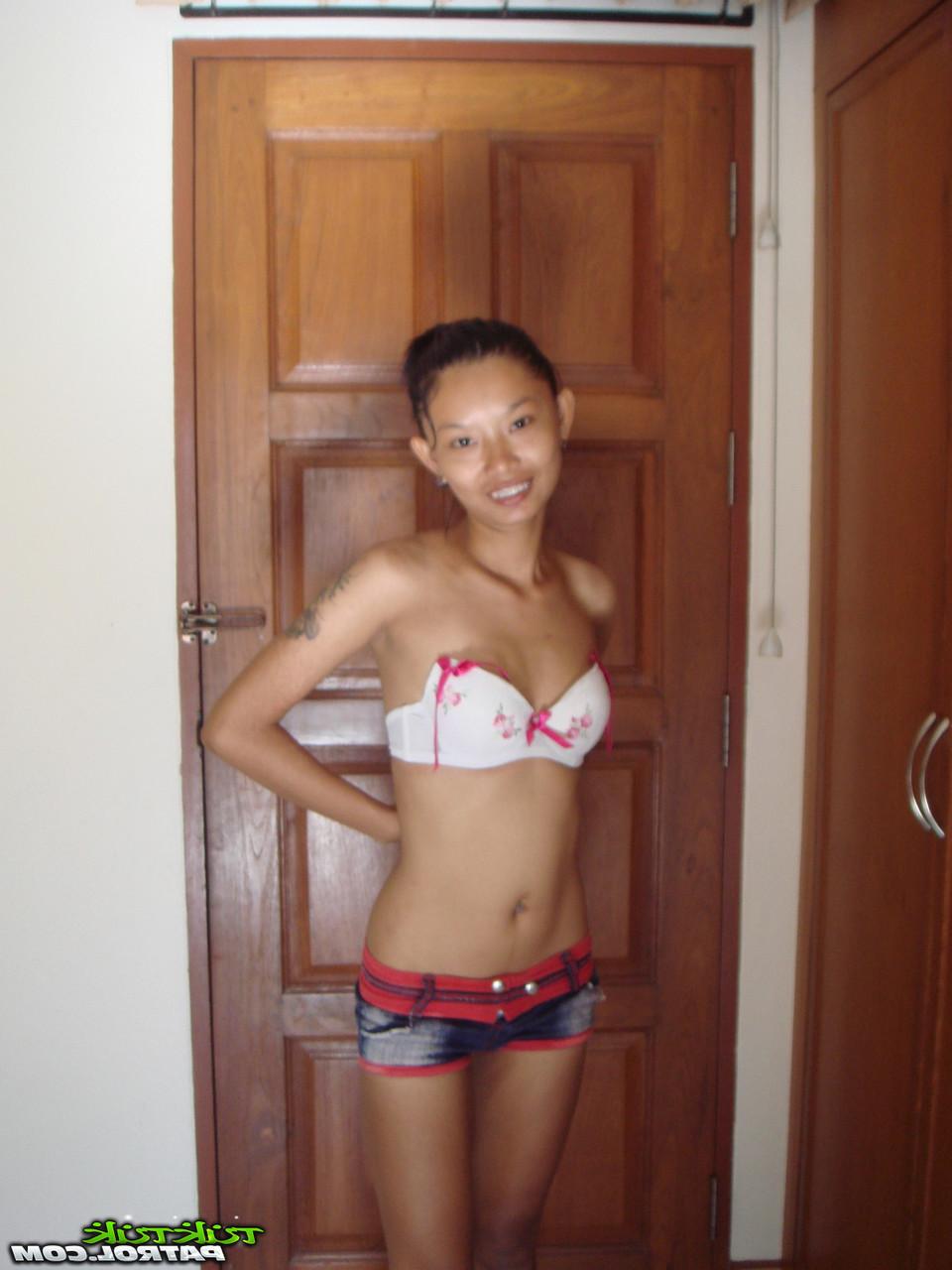 20P Das dünne asiatische Babe Tik enthüllt ihre kleinen Titten und ihre rasierte Muschi