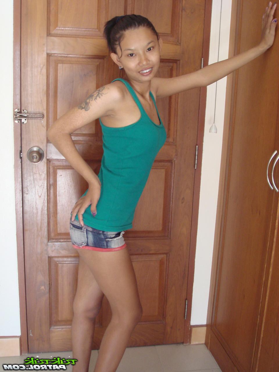 20P Das dünne asiatische Babe Tik enthüllt ihre kleinen Titten und ihre rasierte Muschi