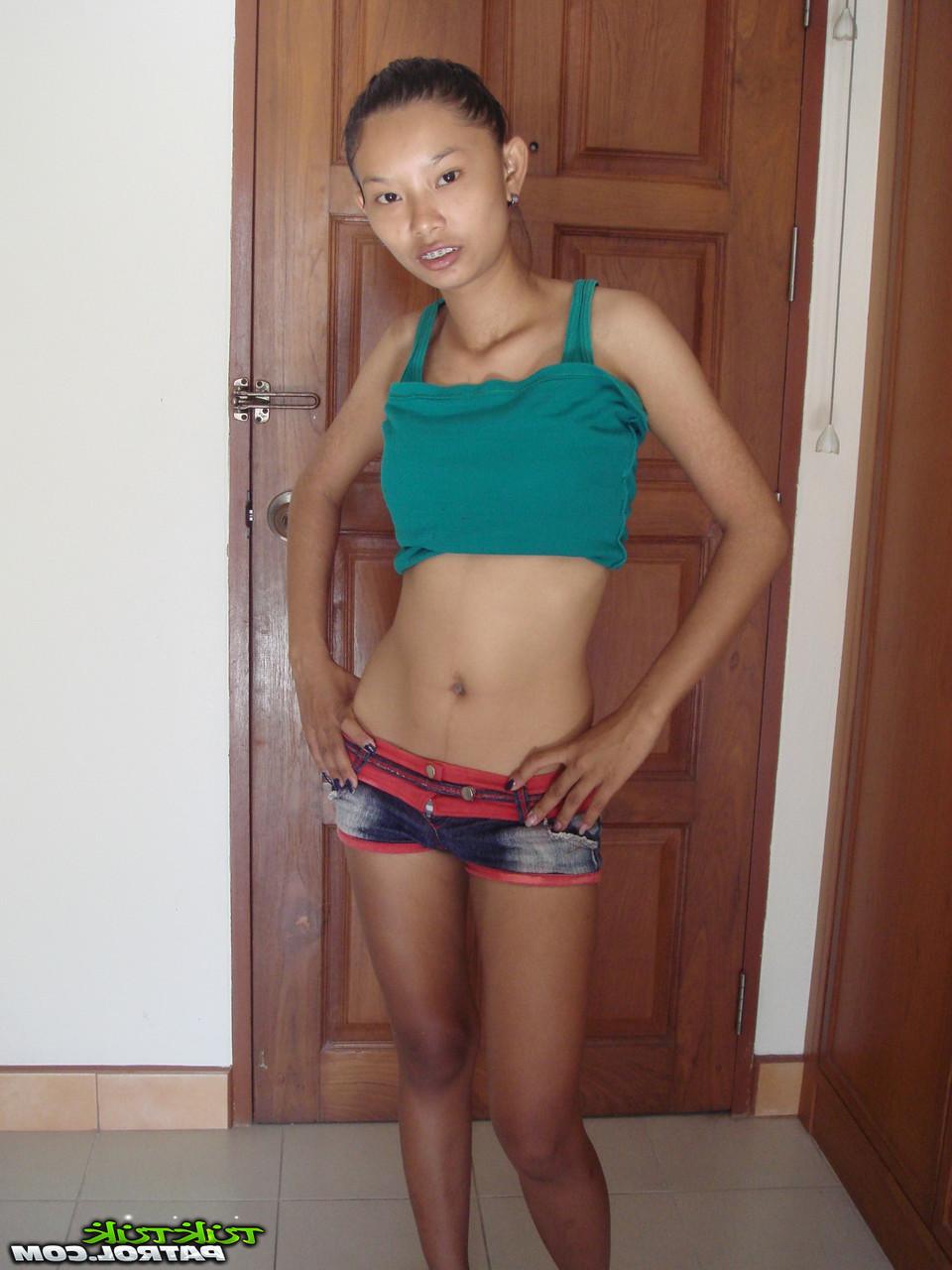 20P Das dünne asiatische Babe Tik enthüllt ihre kleinen Titten und ihre rasierte Muschi