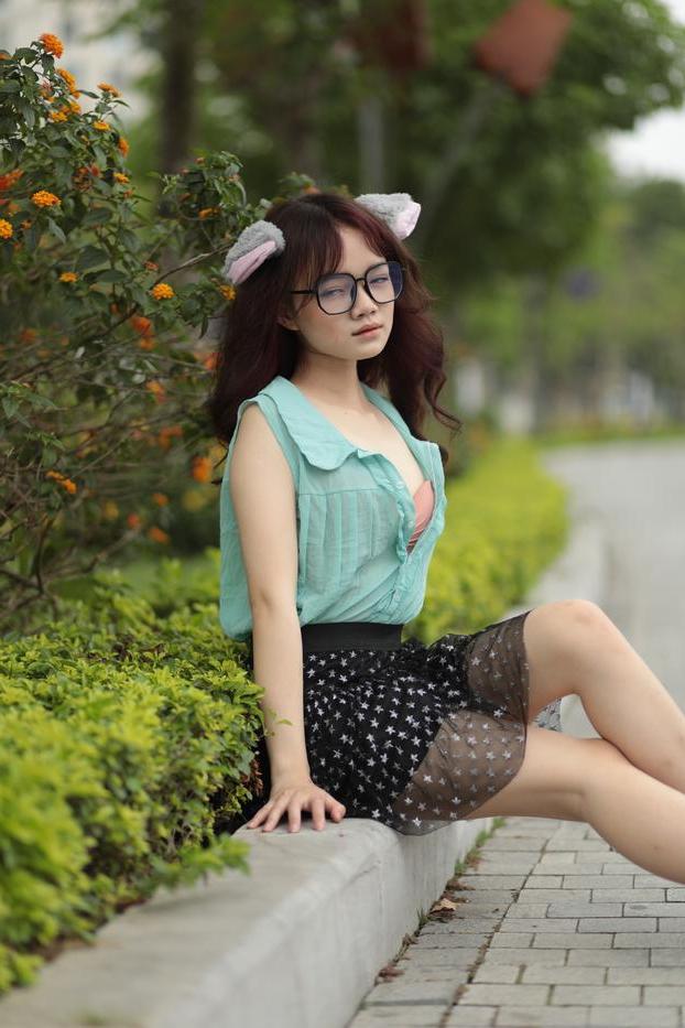 20P Linda adolescente asiática com óculos posa em sua roupa provocante do lado de fora