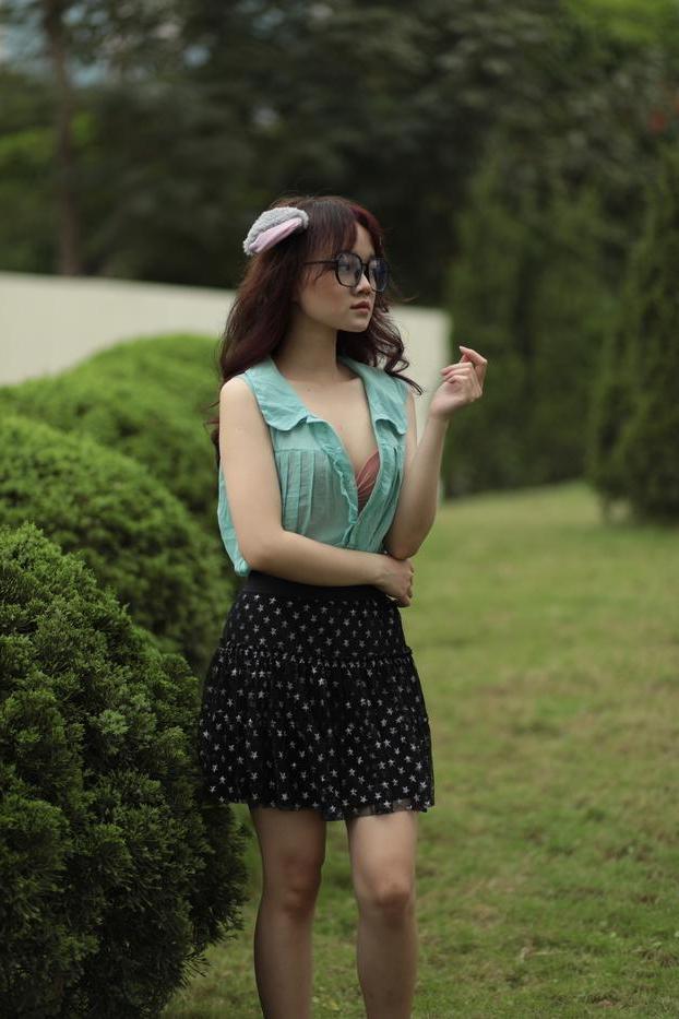 20P Linda adolescente asiática com óculos posa em sua roupa provocante do lado de fora