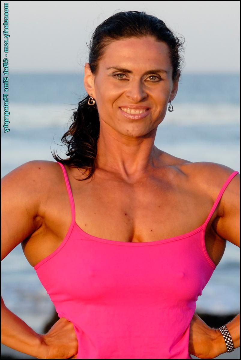 15P Brunette bodybuilder Lada Phihalova flexes at the beach in a tank top & shorts