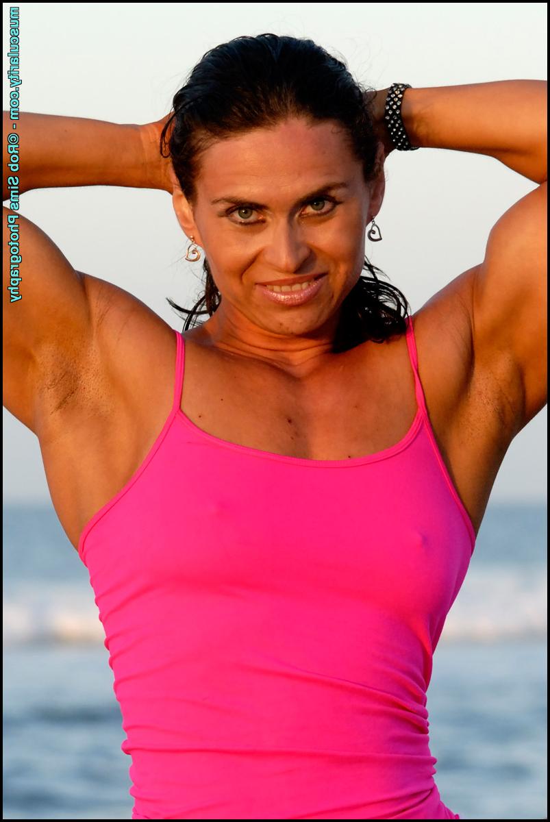 15P Brunette bodybuilder Lada Phihalova flexes at the beach in a tank top & shorts