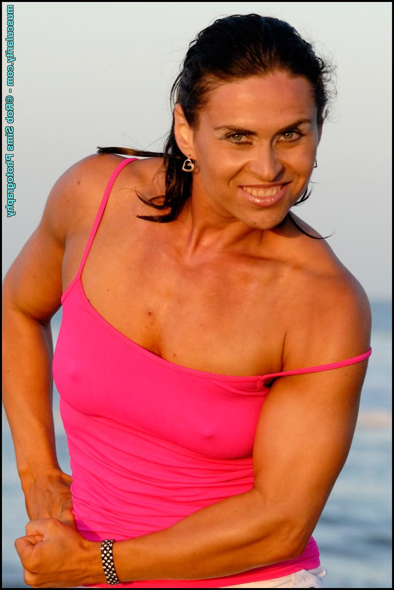 15P Brunette bodybuilder Lada Phihalova flexes at the beach in a tank top & shorts