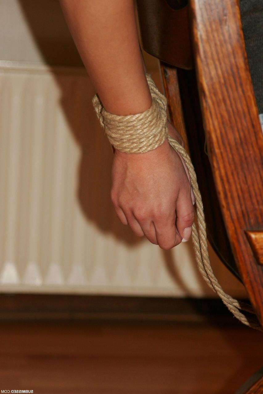 20P Braless brunette Leyla gagged and tied to a chair in a shirt, jeans & boots