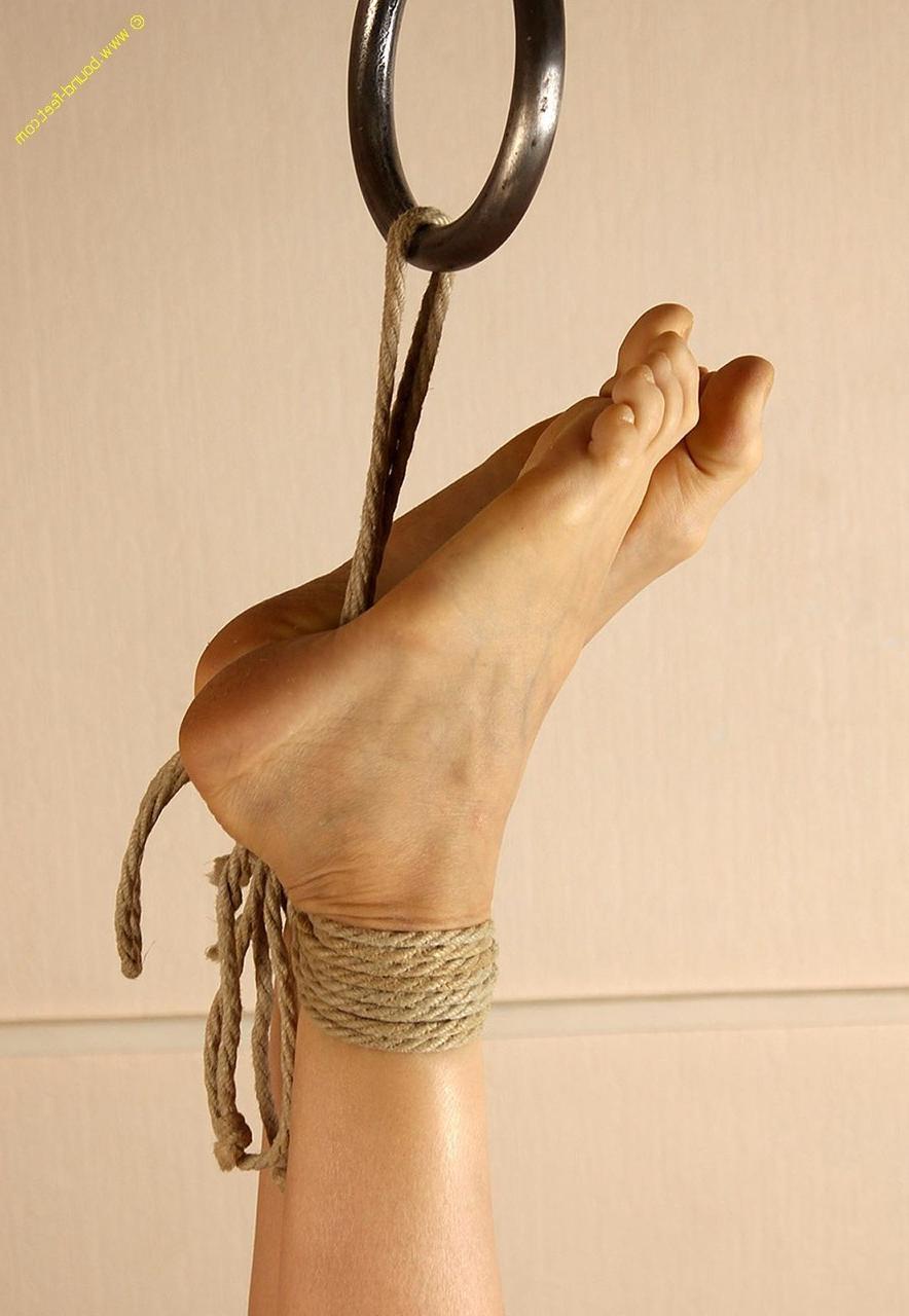 16P Mujer desnuda está sujeta con cuerdas alrededor de los tobillos de sus pies descalzos.