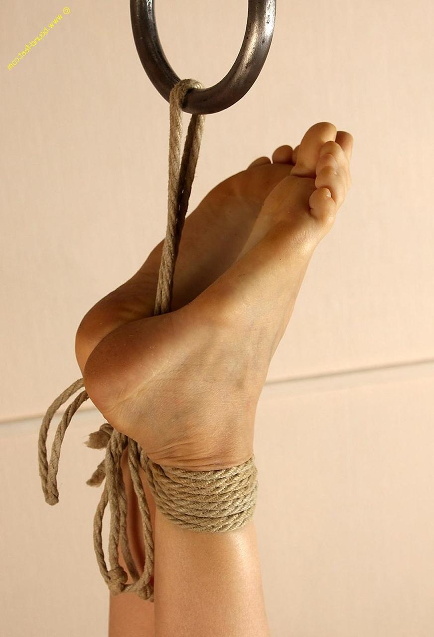 16P Mujer desnuda está sujeta con cuerdas alrededor de los tobillos de sus pies descalzos.