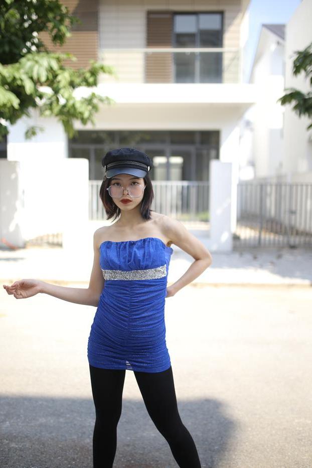 20P Bela asiática com óculos e chapéu Irena posa com seu vestido azul justo do lado de fora