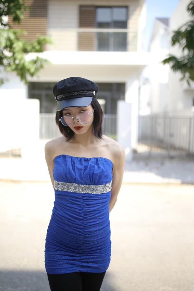 20P Bela asiática com óculos e chapéu Irena posa com seu vestido azul justo do lado de fora