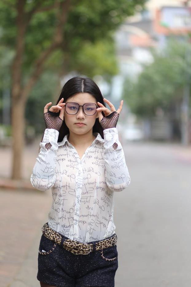 20P Nerdy Asian babe Natalia posing in her white blouse and denim shorts outside