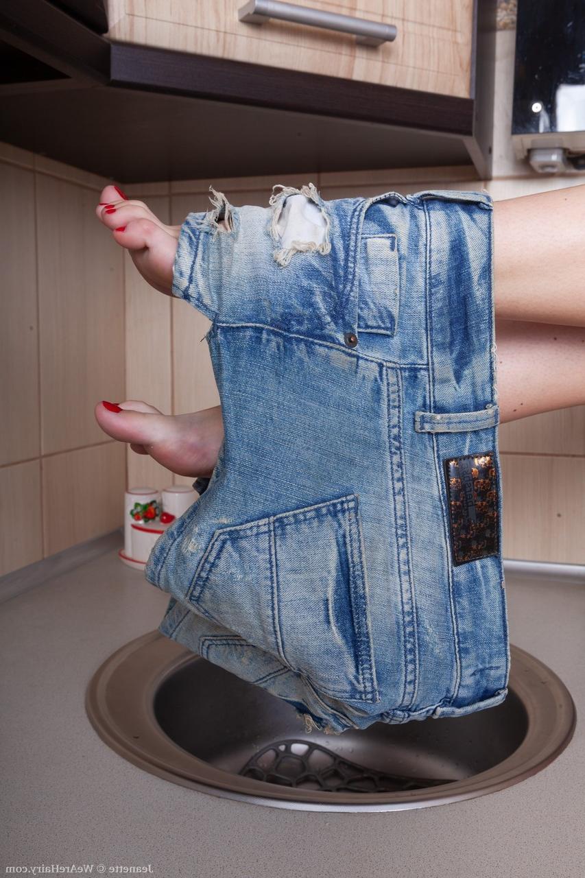 20P Jeanette, une femme de ménage brune et sexy, expose sa chatte poilue dans la cuisine.