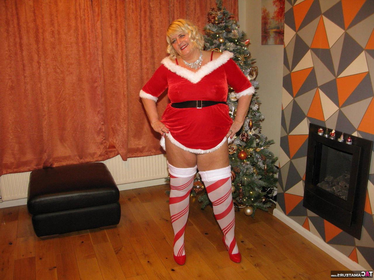 16P La blonde BBW Chrissy Uk montre son gros cul et ses seins près d'un sapin de Noël.