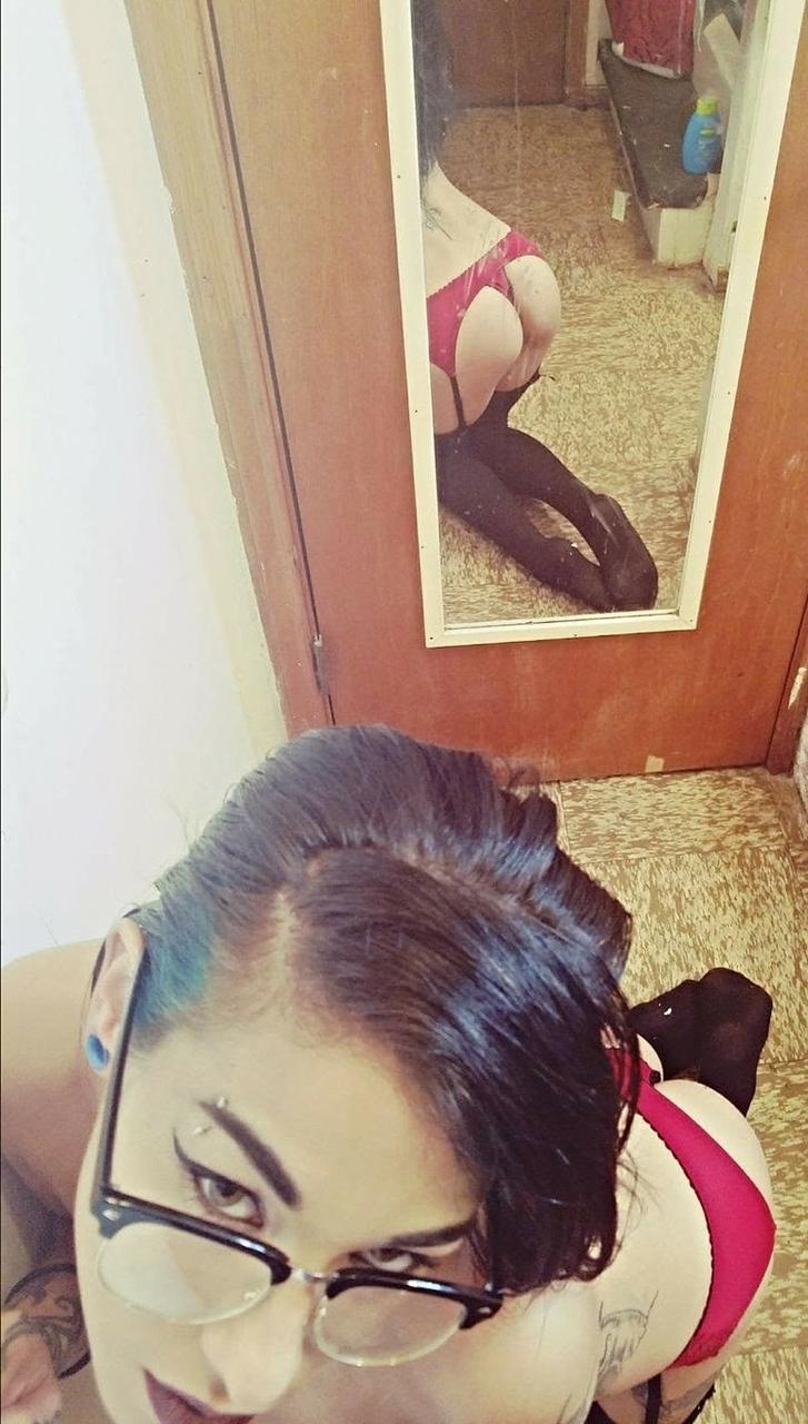 15P Das dünne Amateur-Babe Reign Rae stellt ihren tätowierten Körper zur Schau, während sie oben ohne posiert