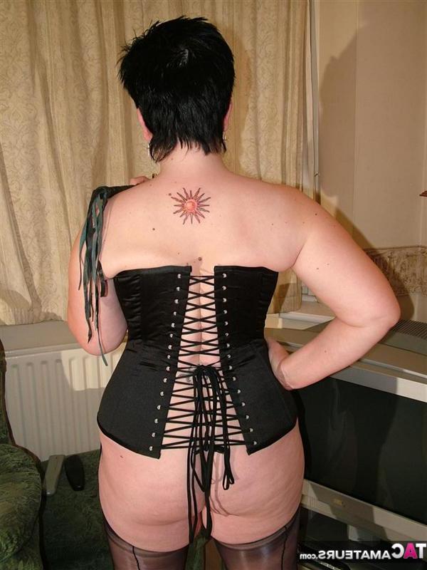16P British pumper Double Dee models a back laced corset in nylons and heels