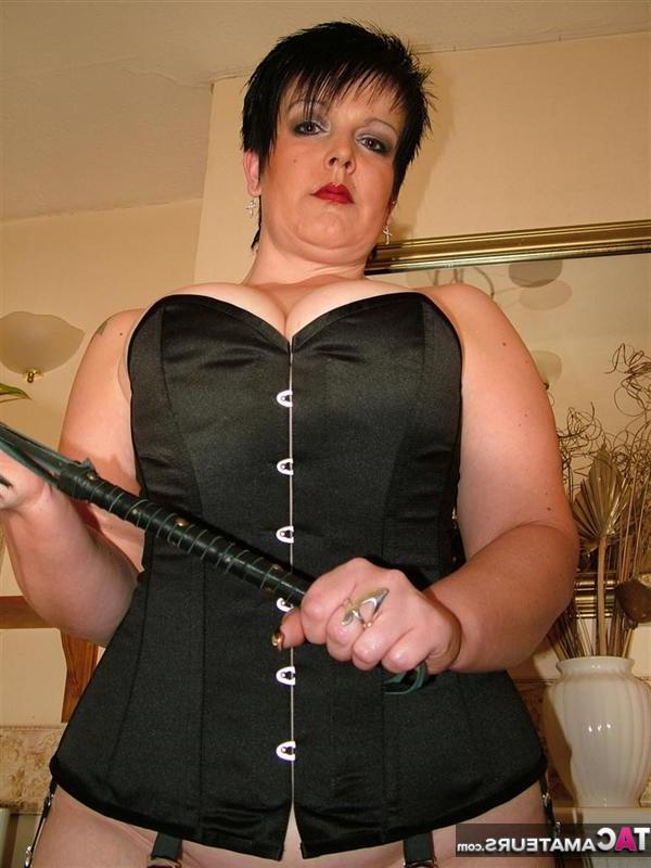 16P British pumper Double Dee models a back laced corset in nylons and heels